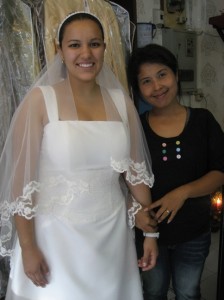 Elaine Villalobos poses with the Bangkok dressmaker who fashioned a wedding gown in three days for less than a tenth of what the design would have cost in the States.