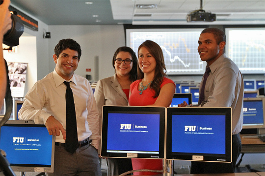 Student lab interns Justin Garcia and Christine Montero; Kathy Grau, lab manager; and Shaun Hoyes, associate director, during the photo shoot for the article in Financial Planning